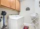 Laundry room with overhead cabinets, a white washer/dryer set, and drying rack at 605 San Augusto Dr, Kissimmee, FL 34759