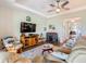 Inviting living room features tray ceilings, wood-look tile floors, comfortable seating, and a ceiling fan at 605 San Augusto Dr, Kissimmee, FL 34759