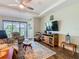Bright living room with sliding glass doors, a ceiling fan, wood-look tile floors and comfortable seating at 605 San Augusto Dr, Kissimmee, FL 34759