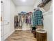 Spacious walk-in closet featuring wood-style tile flooring and ample storage with white wire shelving and hanging rods at 605 San Augusto Dr, Kissimmee, FL 34759