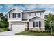 Charming two-story home with blue shutters, stone accents, landscaped yard, and an attached two-car garage at 6167 Daphne St, Lake Hamilton, FL 33851