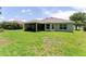 Wide view of the home's backyard and screened in patio with well-maintained lawn at 6644 Sw 179Th Court Rd, Dunnellon, FL 34432