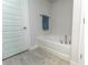 Bathroom boasts a soaking tub with tile flooring, a towel rack, and white door at 6644 Sw 179Th Court Rd, Dunnellon, FL 34432