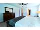 Large bedroom with a ceiling fan, dark wood dresser and a view into the walk-in closet at 6644 Sw 179Th Court Rd, Dunnellon, FL 34432