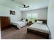 Bright bedroom featuring two twin beds, a ceiling fan, and a vibrant Mario Bros wall art at 6644 Sw 179Th Court Rd, Dunnellon, FL 34432