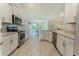 Modern kitchen with white cabinetry, stainless steel appliances, and wood look floors at 6644 Sw 179Th Court Rd, Dunnellon, FL 34432