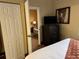 Comfortable bedroom with a TV and a glimpse into another room, offering a cozy living space at 7601 Canada Ave, Orlando, FL 32819