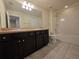 Bathroom boasts double sinks with dark cabinets and a shower-tub combo at 1069 Pavia Dr, Apopka, FL 32703