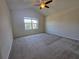 Spacious bedroom features neutral carpet, ceiling fan, and a sunny window at 1069 Pavia Dr, Apopka, FL 32703