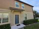 Home entrance featuring a blue door, beige trim, and manicured bushes at 1069 Pavia Dr, Apopka, FL 32703