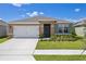 Charming single-story home featuring a well-maintained lawn and a two-car garage on a sunny day at 1102 Tupelo Trl, Haines City, FL 33844