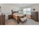 Comfortable bedroom with a queen-size bed, neutral walls, and a large window offering natural light at 1102 Tupelo Trl, Haines City, FL 33844