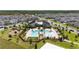 A stunning aerial view shows the community pool and amenity center surrounded by many homes at 11328 Listening Dr, Orlando, FL 32832