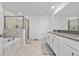Well-lit bathroom featuring a double sink vanity, soaking tub, and glass-enclosed shower at 11328 Listening Dr, Orlando, FL 32832