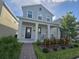 Charming two-story home with a welcoming front porch, blue door, and beautiful landscaping at 11328 Listening Dr, Orlando, FL 32832
