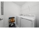 Bright laundry room with a washer, dryer, overhead shelving, and laundry supplies cart for convenient home cleaning at 11328 Listening Dr, Orlando, FL 32832