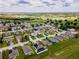 Neighborhood aerial view with houses and lush landscaping, showcasing a peaceful setting near a lake and green spaces at 1158 Legatto Loop, Dundee, FL 33838
