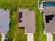 Aerial view of the home featuring solar panels, a well-manicured lawn, and a clean driveway leading up to the house at 1158 Legatto Loop, Dundee, FL 33838