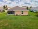 Aerial view of a home's backyard, featuring a screened-in patio and lush green lawn at 1158 Legatto Loop, Dundee, FL 33838