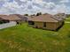 A well-maintained backyard and exterior, including a green lawn, solar panels on the roof and a screened patio at 1158 Legatto Loop, Dundee, FL 33838