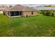 Aerial view of a spacious backyard featuring a well-maintained lawn and outdoor living space at 1158 Legatto Loop, Dundee, FL 33838