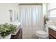Bathroom featuring a shower with a white curtain, toilet, and decorative accents at 1158 Legatto Loop, Dundee, FL 33838