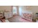Charming Bedroom with pink accents, plush rug, and a crib with patterned bedding at 1158 Legatto Loop, Dundee, FL 33838