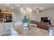 Stylish dining area with a decorative chandelier, flowing into the living room and kitchen at 1158 Legatto Loop, Dundee, FL 33838
