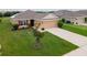 Inviting single-story home with red shutters, a manicured lawn, and solar panels for energy efficiency at 1158 Legatto Loop, Dundee, FL 33838