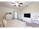 Bright main bedroom with white furniture, a ceiling fan, and a large window at 1158 Legatto Loop, Dundee, FL 33838