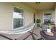 Relaxing covered patio with comfortable seating, plants, and a hammock at 1158 Legatto Loop, Dundee, FL 33838