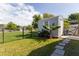 Backyard view features a storage shed on a green lawn, complemented by a lake view and a stone-paved walkway at 121 White Birch Dr, Kissimmee, FL 34743