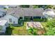 Aerial view of the backyard featuring a spacious patio, lush landscaping, and a partial view of the home's exterior at 121 White Birch Dr, Kissimmee, FL 34743