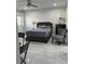 Bedroom featuring modern gray bedding, side tables with lamps, and stylish chair on white marble tile floors at 121 White Birch Dr, Kissimmee, FL 34743