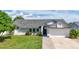 Charming single-story home features a well-manicured lawn, brick walkway, and a two-car garage at 121 White Birch Dr, Kissimmee, FL 34743