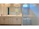 Bright bathroom showcasing double sinks, modern lighting, and a glass-enclosed shower at 1222 Yorkshire Ct, Davenport, FL 33896