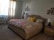 Serene bedroom featuring a tufted headboard, decorative pillows, soft carpet, and bedside tables with lamps at 1222 Yorkshire Ct, Davenport, FL 33896