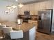 Stylish kitchen featuring a granite island with bar stool seating, stainless steel appliances, and modern cabinetry at 1222 Yorkshire Ct, Davenport, FL 33896