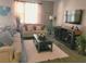 Cozy living room with a large TV, plush sofas, and a decorative coffee table on a soft, white rug at 1222 Yorkshire Ct, Davenport, FL 33896
