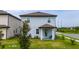 This is the backyard of a two-story home that offers a covered back porch and green landscaping at 1335 Greenfield Loop, Kissimmee, FL 34747