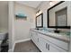 Bathroom features a double sink vanity with granite countertops, modern black fixtures, and gray wood-style floors at 1335 Greenfield Loop, Kissimmee, FL 34747