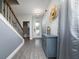 Bright entryway featuring wood-look flooring, stairway and view of a half bathroom at 1335 Greenfield Loop, Kissimmee, FL 34747