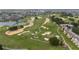 Expansive golf course with manicured greens, serene water features, and nearby residential buildings at 1335 Greenfield Loop, Kissimmee, FL 34747
