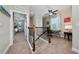 View of hallway between bedrooms and a desk area, carpet flooring, and wrought iron railing at 1335 Greenfield Loop, Kissimmee, FL 34747