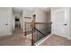 Hallway with carpeted floors, white doors, and a staircase with a dark metal railing at 1335 Greenfield Loop, Kissimmee, FL 34747