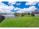 A well-maintained yard leads to a wrought iron fence with lake and neighborhood views at 13525 Mallard Cove Blvd, Orlando, FL 32837