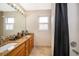Bathroom featuring double vanity, granite countertop, large mirror, and shower at 13525 Mallard Cove Blvd, Orlando, FL 32837