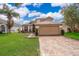Lovely two-story home featuring a paver driveway, two-car garage, and beautiful lawn at 13525 Mallard Cove Blvd, Orlando, FL 32837