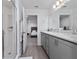 Bathroom with double sinks, gray cabinets, and a glass-enclosed shower stall at 1719 Daystar Dr, Haines City, FL 33844