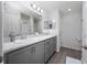 Bathroom with a double sink vanity, gray cabinets, and a large mirror at 1719 Daystar Dr, Haines City, FL 33844
